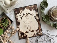 It is well with my soul wood burned picture surrounded by decorative objects.