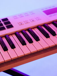 Close-up of white keyboard with magenta and purple light streaks – dreamy, minimalist brand detail shot by Mewphotovideo