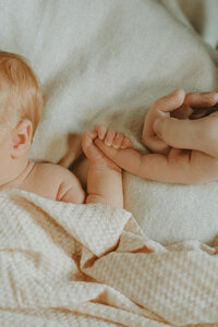 photo of a newborn holding dad's hand