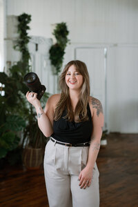 woman smiling while holding her camera