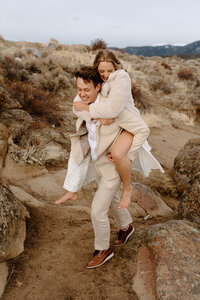 groom giving bride piggyback ride