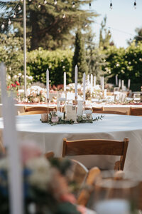 Elegant outdoor wedding reception table setting featuring white candles and lush floral centerpieces under glowing string lights, captured in a romantic Pacific Northwest wedding venue near Eugene, Oregon.