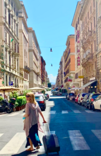 Heather Deyo pulling a suitcase along a European street.