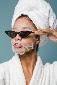 Woman wearing a sheet mask and sunglasses for spa day