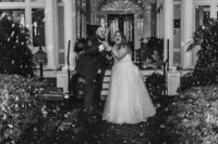 A wedding couple popping a bottle of champagne 