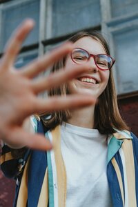 Girl with glasses waving to the camera