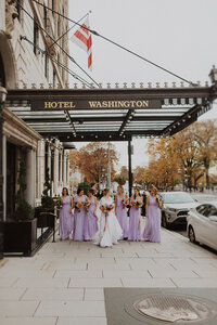 Bridesmaids pose with bride in front of Hotel Washington in DC wedding 