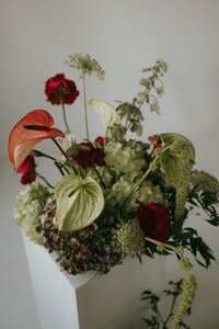 Studio brand photo with flowers arranged on top of a column