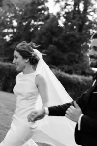 Bride runs happily holding her groom's hand
