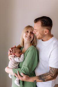 Mutter und Vater halten Baby auf dem Arm