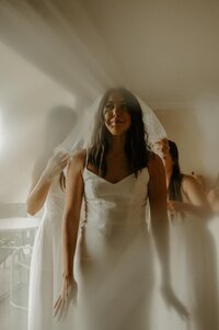 Editorial wedding dress hanging in moodyvenue window, cinematic film style