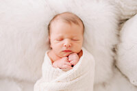sleeping baby boy on bed with dads hand tucking him in during Springfield MO photography session