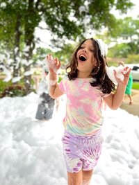 child shouting with joy while foam rains down