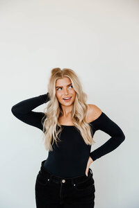 A person with one hand in their hair and the other on their hip