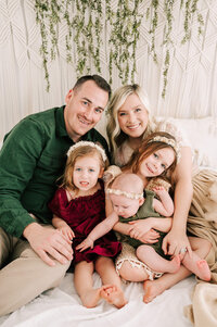 family snuggling in bed enjoying their family photography in Springfield MO by The XO Photography