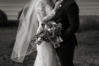 Bride and Groom in Black and White, bride's veil is flying in the wind at an intimate chapel in Lancaster, PA