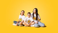three kids sitting together while wearing smiley face t-shirts