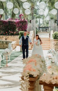 Bride walks down the aisle to meet her groom surrounded by flowers
