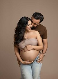 Couple taking a maternity photo in Atlanta GA. Dad is making mom laugh while holding her baby bump.