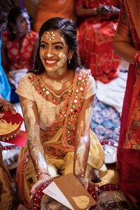 Indian Bride smiling while covered in Henna
