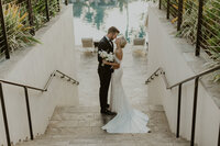 bride and groom kissing on stairs