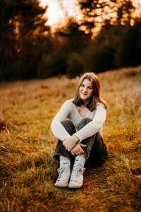 A tranquil senior portrait capturing a moment of reflection, set in the autumnal woods of Vermont.