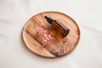 Bottle of essential oil sitting on a wooden platter