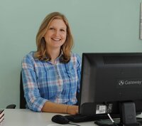 Maureen sitting at desk in  2016