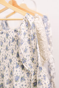 White floral dresses hanging on wooden hangers taken by Cincinnati Newborn Photographer