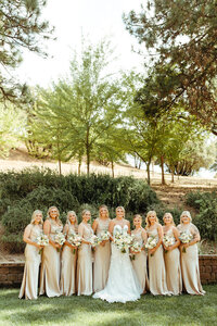 bride posing with her bridesmaids wearing champagne bridesmaids dresses