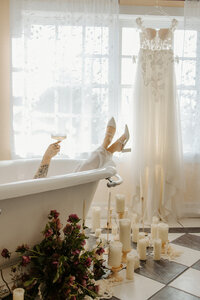 Editorial bridal portrait posing with champagne in a bathtub