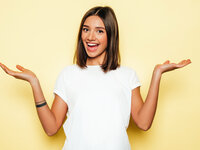 Woman in white shirt shrugging on yellow background