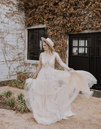 Boho bride on her wedding day wearing trendy and modern hat.