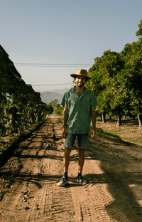 Mason Hernandez Farm Dinner LA chef and founder standing in farm fields in LA on sunny day