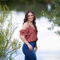 high school senior girl standing by a pond