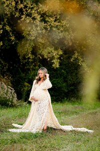 boho styled waxhaw, nc studio maternity photo of a blonde expectant mom in a cream dress with  a tree in the foreground