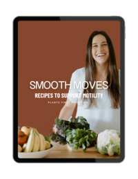 Woman smiling in a kitchen with bowls of fruits and vegetables on the counter