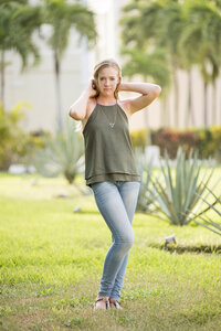 Woman posing for portrait outside wearing jeans and a tank