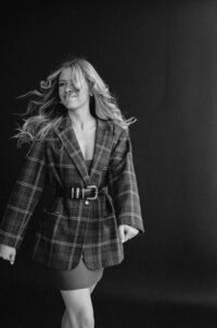 Black and white photo of Emily walking towards the camera while wearing a Burberry inspired outfit.