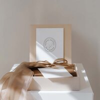 Athena Kristen wedding planner brand packaging with linen gift box, gold ribbon, and branded stationery card, styled in soft natural light for a refined and elegant presentation.
