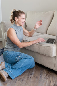 Stephanie chatting with a client on her laptop on the couch