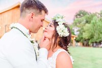 A bride and groom look at each other in front of the venue at Camelot Meadows.