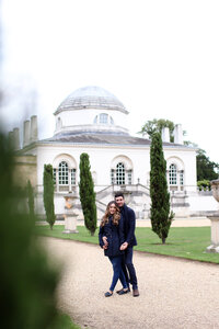 couple-standing-in-front-of-chiswick-house-at-engagement-shoot-in-london-in-chiswick-by-leslie-choucard-photography
