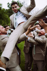 groomsmen lifting groom up before ceremony