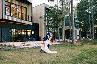 Groom is kissing his Bride while dipping her by the luxuries Catalyst By Nature Link venue  | Minnesota wedding photographer