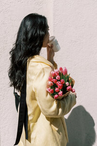 A woman holding a bouquet of pink tulips 