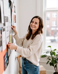 Brand designer, Jordin Brinn, standing in front of a moodboard.