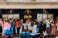 Guests gather at the neon-lit coffee bar inside SoHo63, a Chandler wedding and event venue, during a daytime event. The stylish lounge setup and lively crowd reflect the venue’s modern design and versatility for hosting social gatherings, networking events, and conferences.