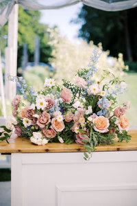 A large floral arrangement on a wooden slab