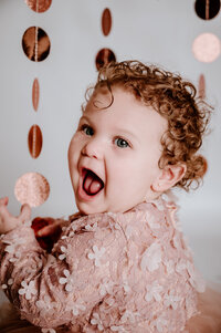 Little girl celebrating first birthday with studio portraits